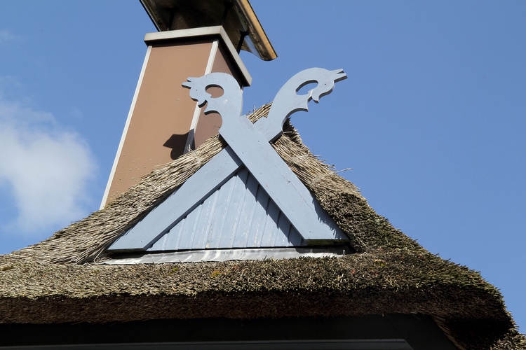 die klassischen Pferdeköpfe eines Reethauses an der Ostsee