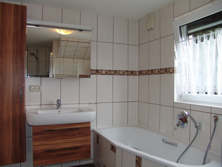 Im modernen Badezimmer befindet sich auch eine Wanne für ein entspannendes Wohlfühlbad.