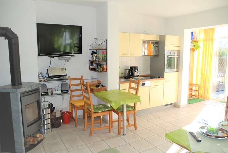 Wohnzimmer mit Einbauküche, Kaminofen