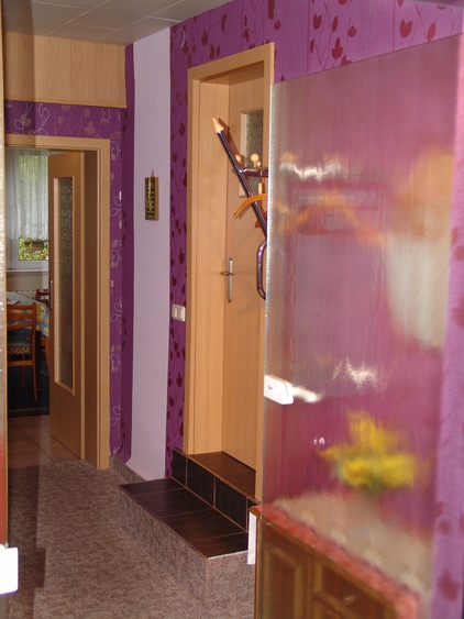 Eingangsbereich mit Blick geradeaus in die große Wohnküche sowie rechts zum Badezimmer.